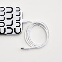 Hvit flettet USB-C-kabel koblet til iPhone 16 Pro Max