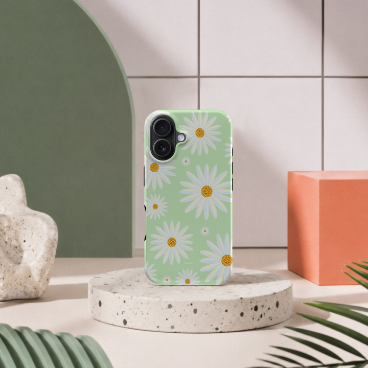 iPhone 16 deksel Kamille med hvite kamilleblomster i moderne pastellinteriør med grønn bue og terrazzo sokkel