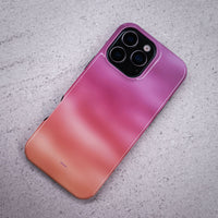 iPhone 16 Pro Max deksel Lilladis med en vakker lilla, rosa og oransje gradient på en lysegrå overflate.
