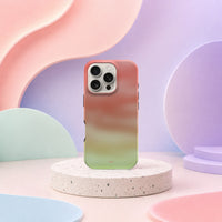 iPhone 16 Pro deksel Koralldis med korallrosa, beige og grønn gradient i mykt pastellinteriør