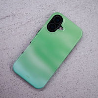 iPhone 16 deksel Myntdis med en myk myntgrønn og lys grønn gradient på en lysegrå overflate.