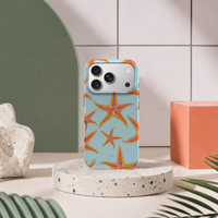 iPhone 17 Pro deksel Sjøstjerner med oransje sjøstjerner i moderne pastellinteriør med grønn bue og terrazzo sokkel